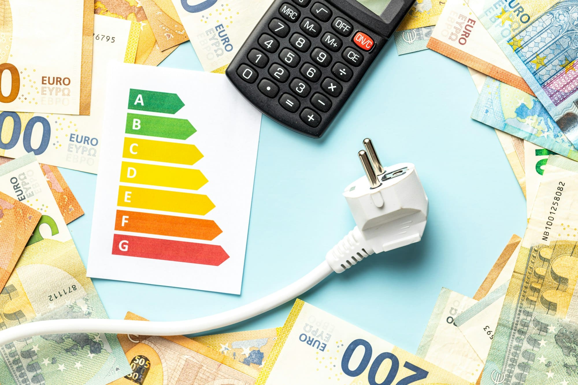 Electric plug, calculator, energy label and euro money on blue background.