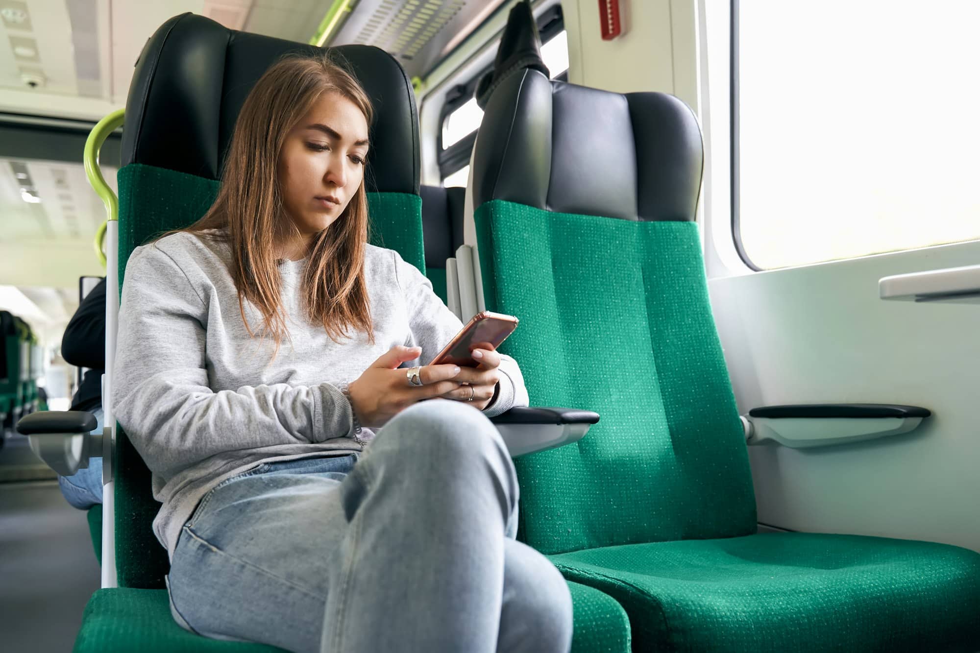 Young woman using smartphone in a train
