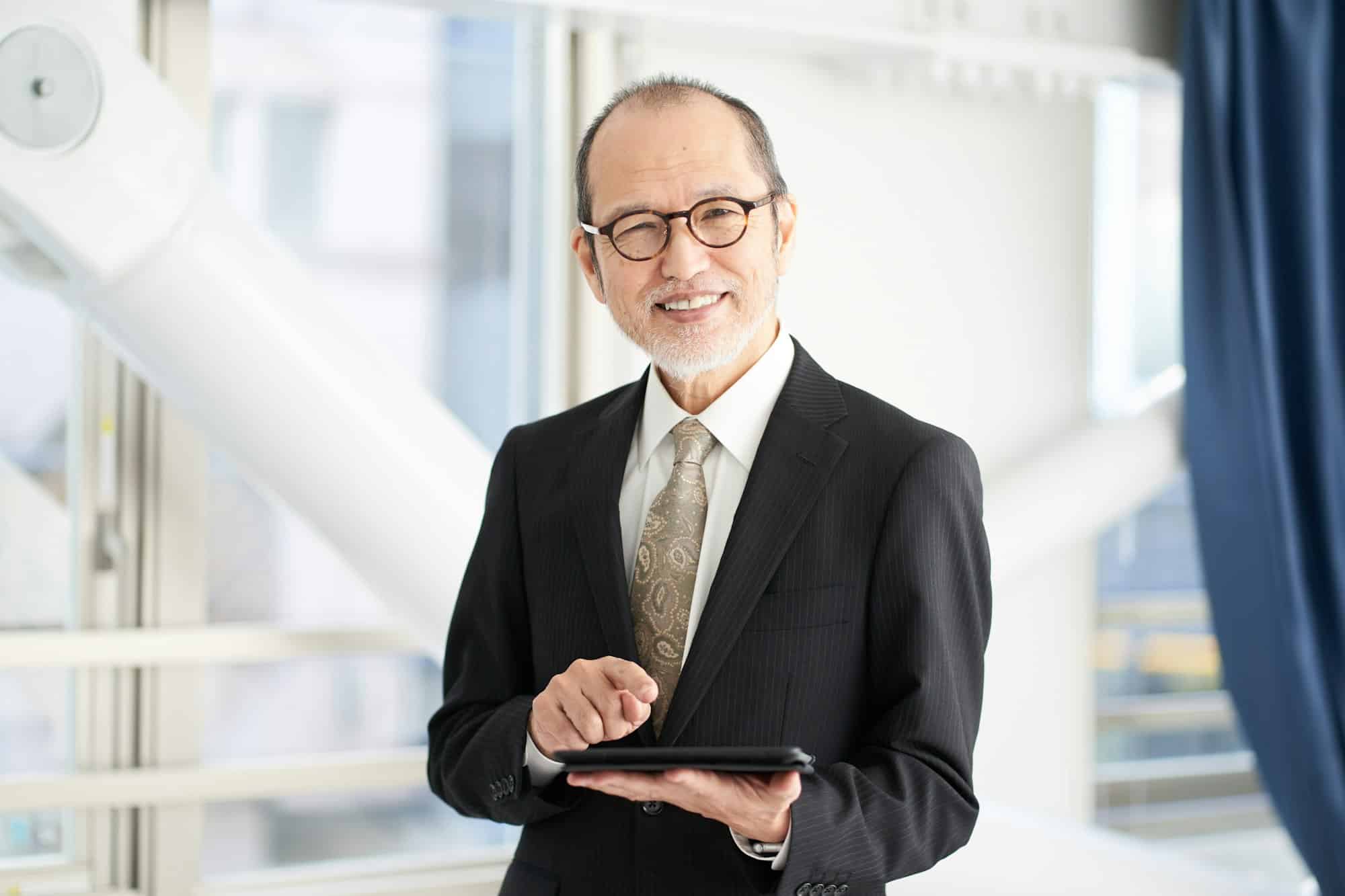 A man in a managerial position at a construction company operating a tablet