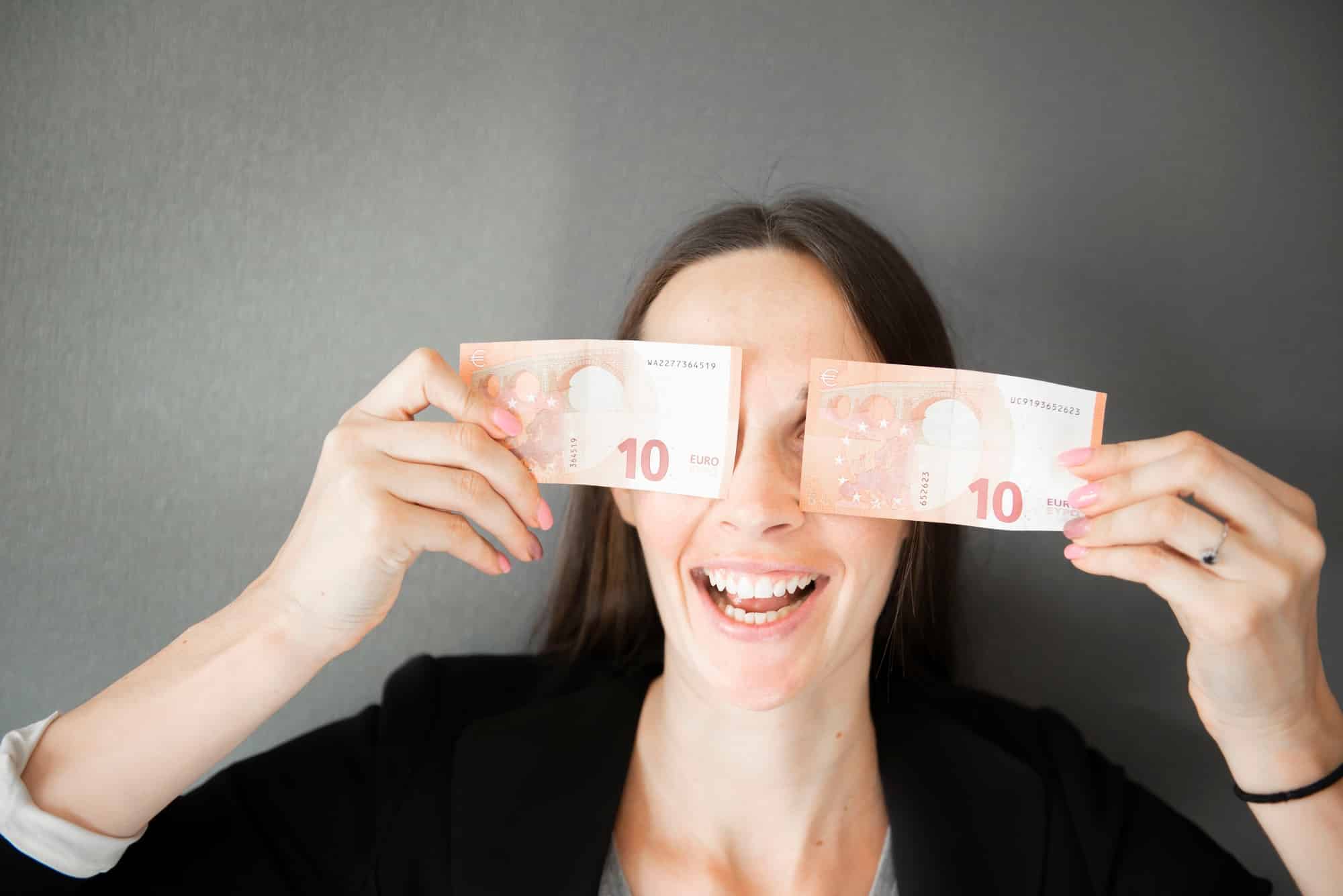 happy female holding euro money, young woman covering her face eyes with 10 euro bills note