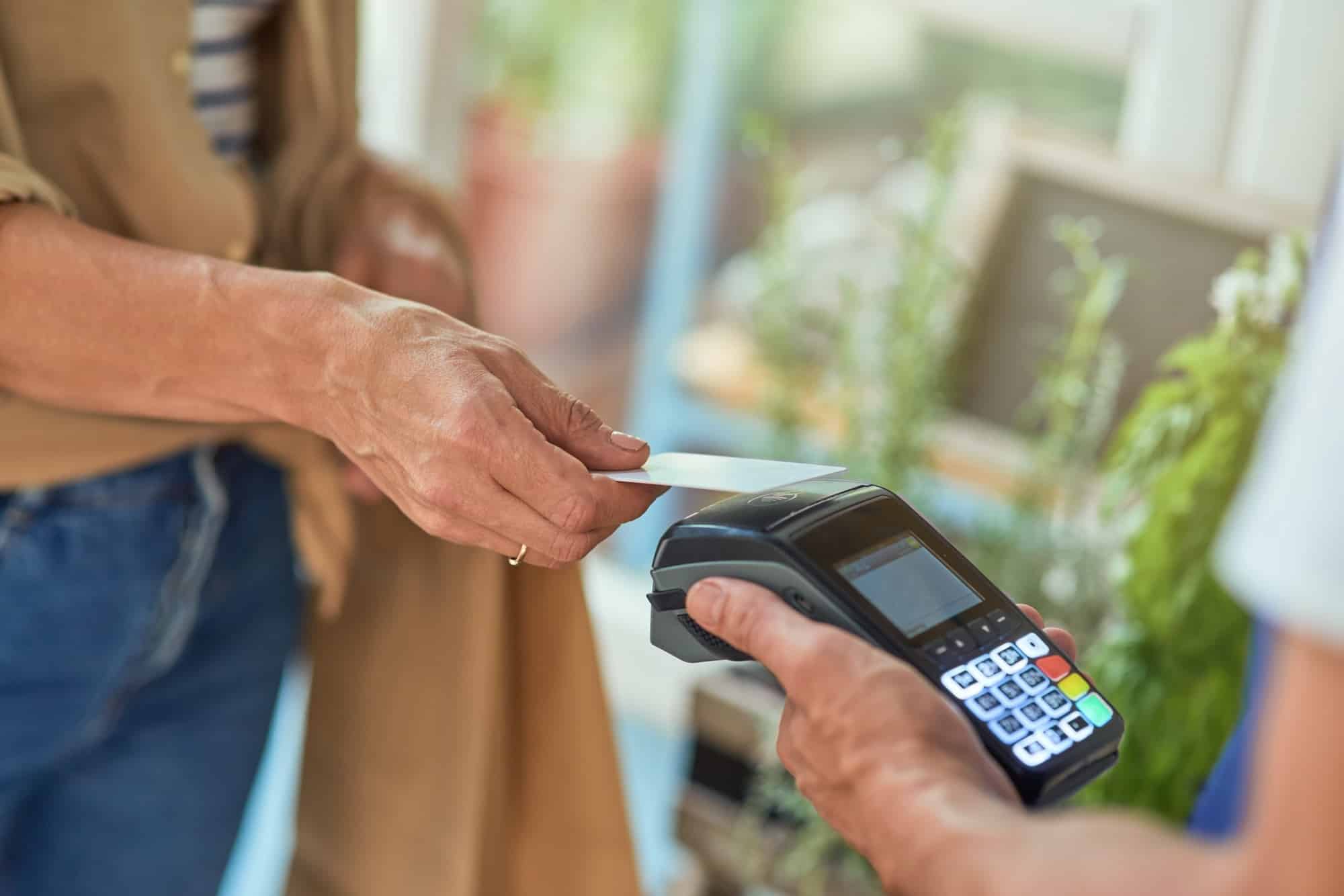 Woman paying with bank card in shop