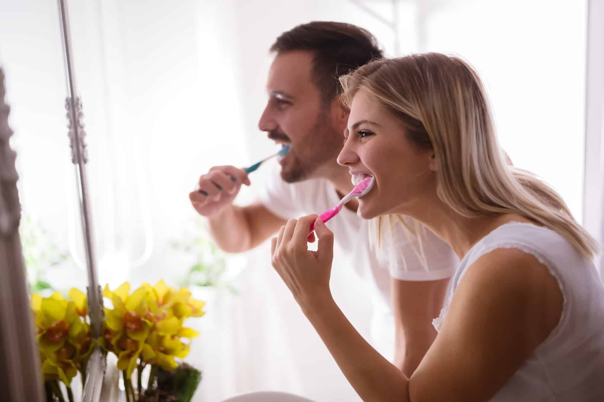 Couple washing teeth in morning