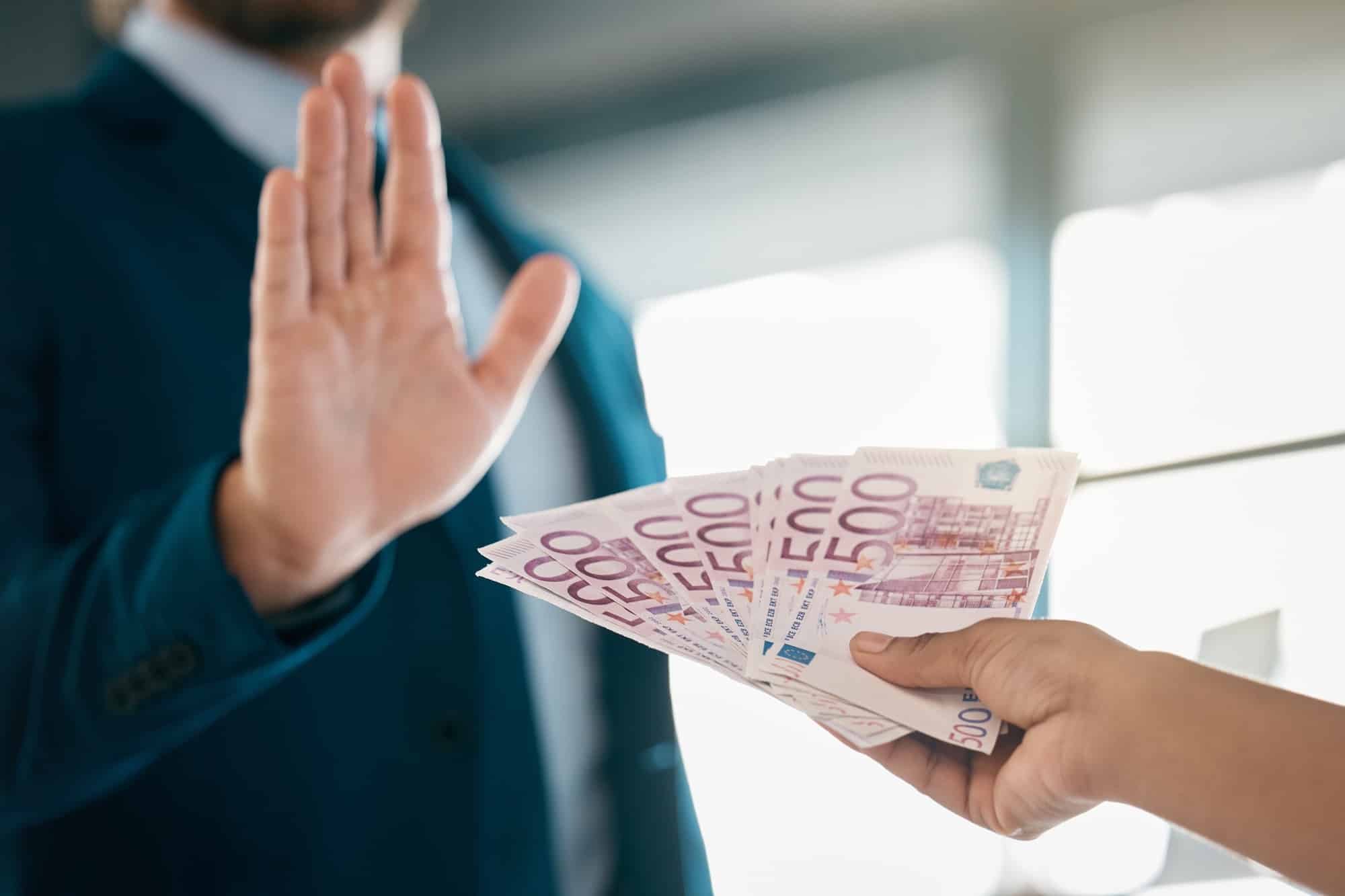 Money, euros and hand of a businessman saying stop fraud, corruption and money laundering in the co