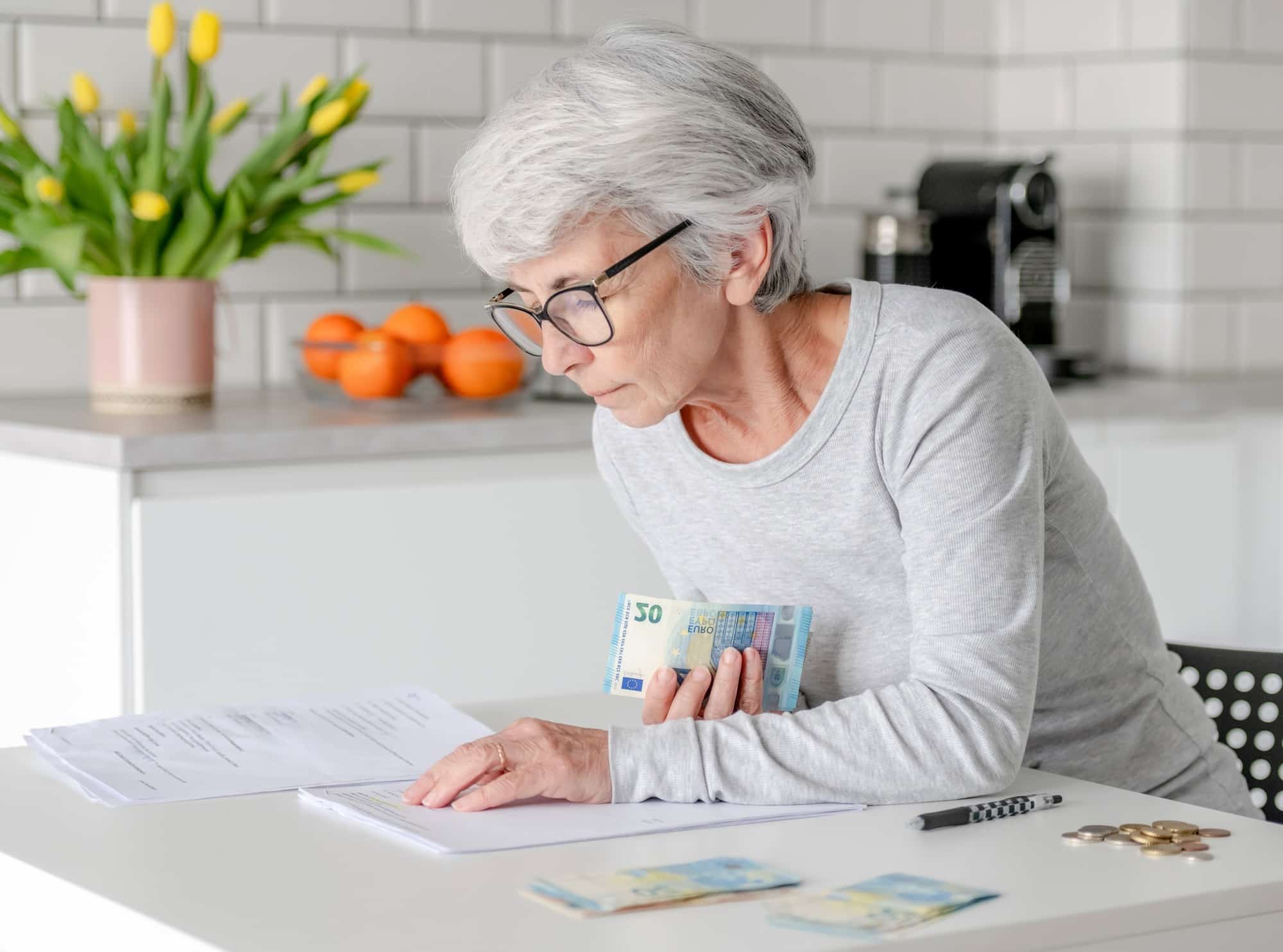 Elderly Woman At Home Holds Euro Money